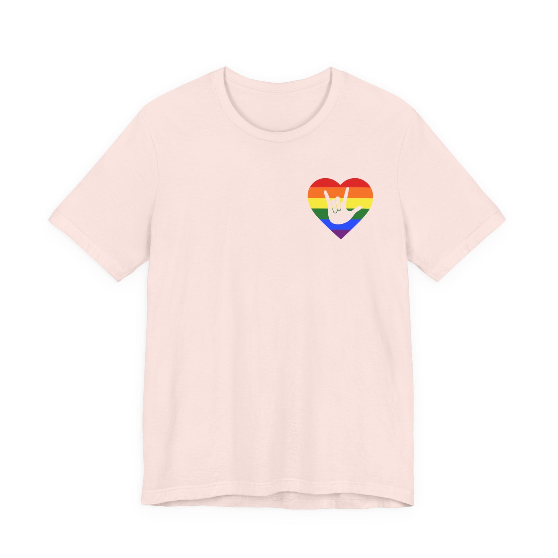 Front view of a soft pink T-Shirt showing a pride coloured heart and the iconic ASL I Love You sign embedded in it on the left side of the chest