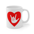 White mug with a red coloured heart design featuring the ASL sign for I Love You embedded in it. The mug handle is on the right hand side of the mug.