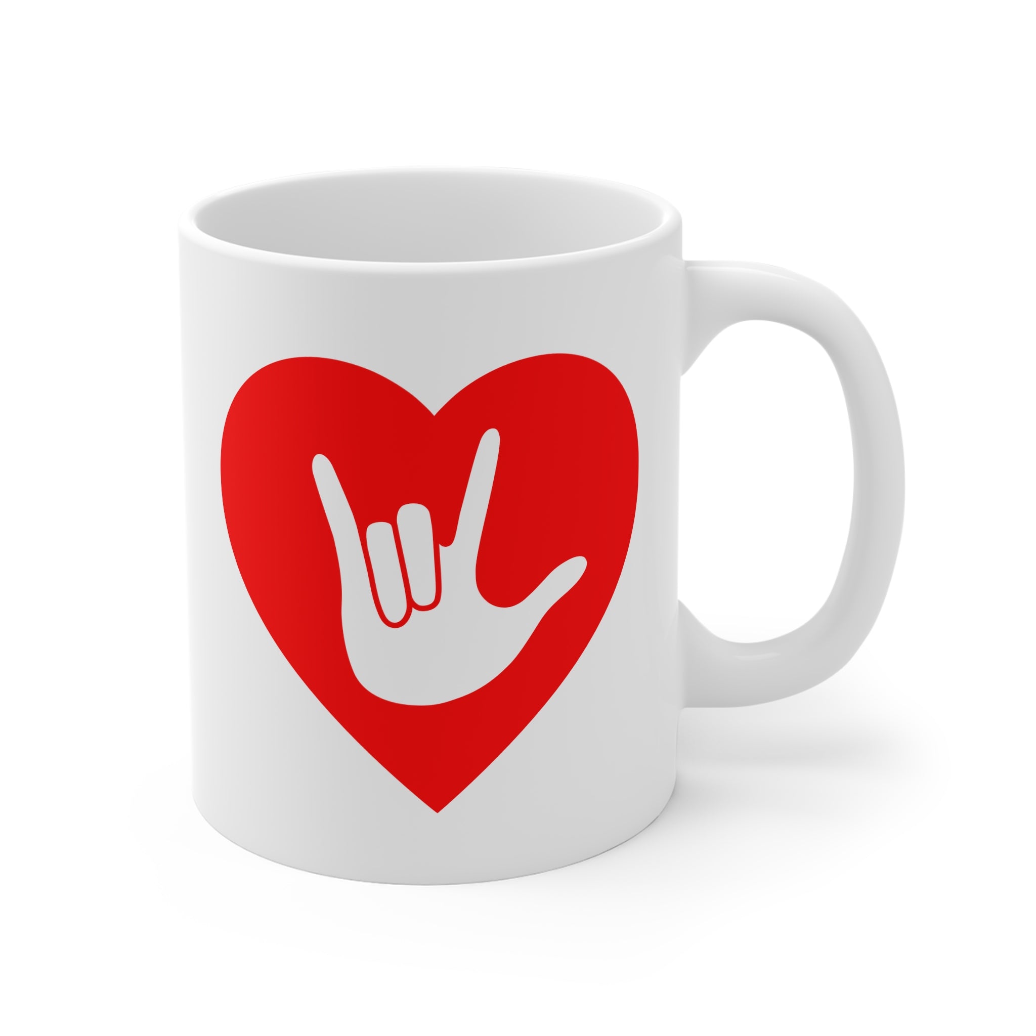 White mug with a red coloured heart design featuring the ASL sign for I Love You embedded in it. The mug handle is on the right hand side of the mug.