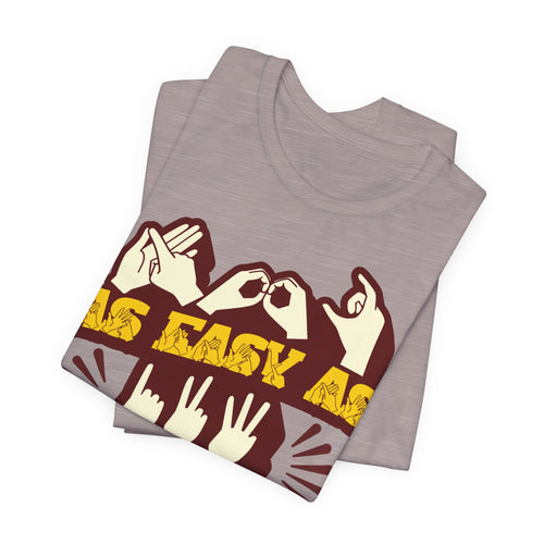 Folded heather pink gravel t-shirt with the phrase ABC As Easy As 123 in Fingerspelling & Text