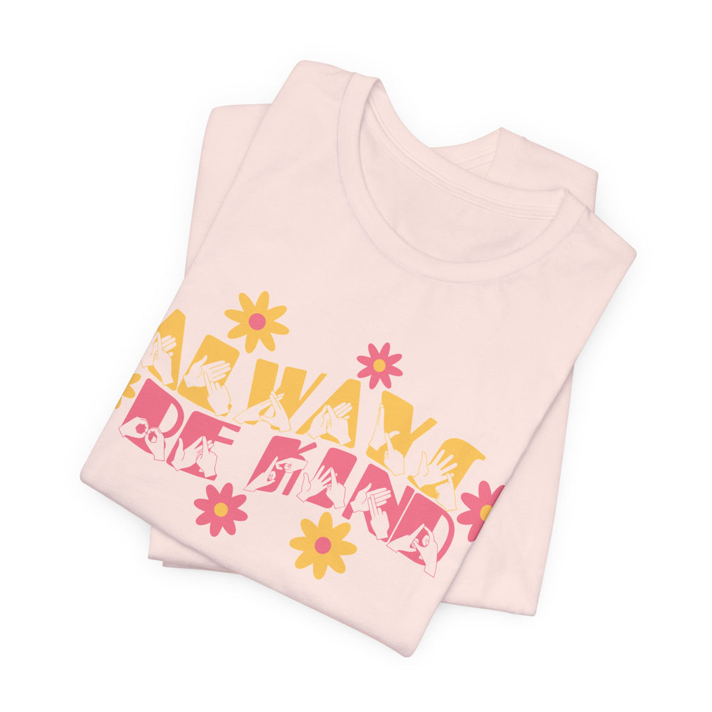 Folded soft pink T-Shirt with the phrase Always Be Kind in BSL fingerspelling and text combined with floral design
