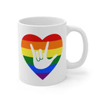 White mug with a rainbow heart design featuring the ASL sign for I Love You embedded in it. The mug handle is on the right hand side of the mug.