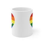 White mug with no handle visible, showing part of the pride coloured heart design on each side.