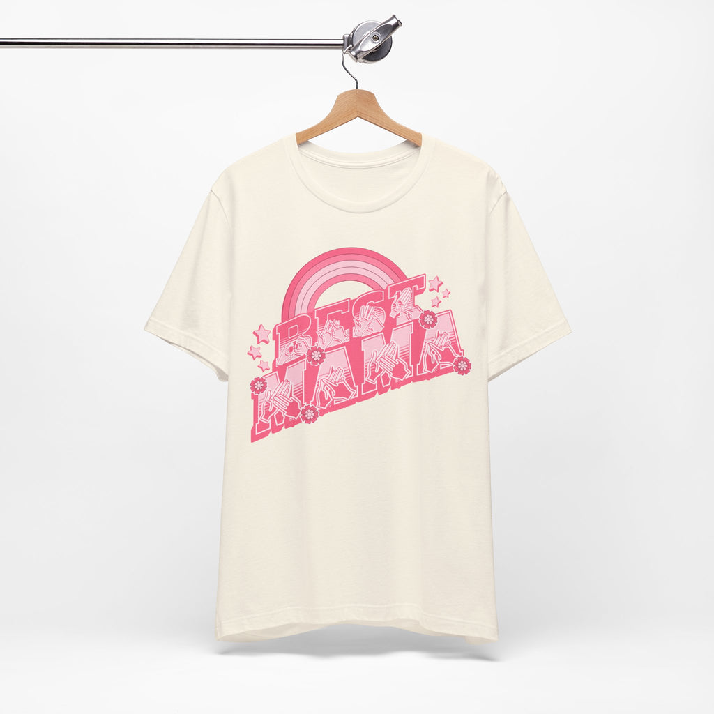 Natural T-shirt with ‘Best Mama’ shown in BSL fingerspelling and text, with rainbow, stars, and floral accents, on a hanger against a white background