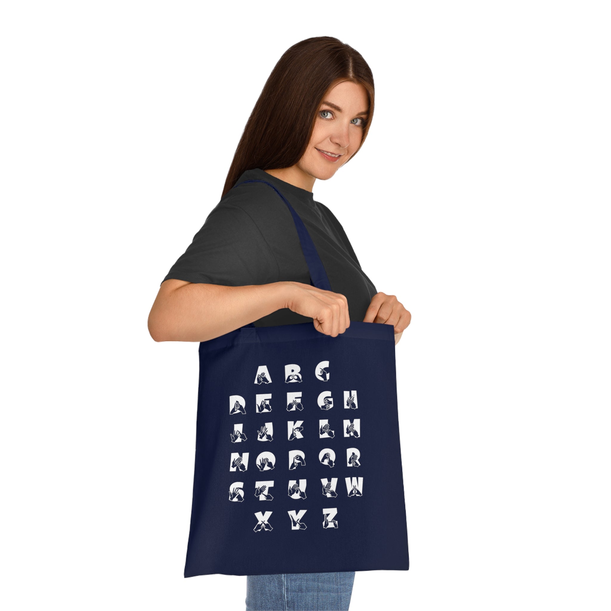 Person holding a navy Tote Bag with BSL Alphabet - White Fingerspelling & Text