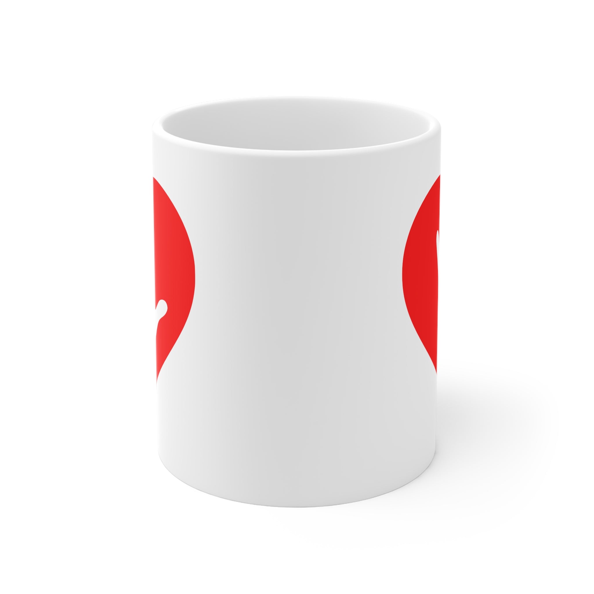 White mug with no handle visible, showing part of the red coloured heart design on each side.