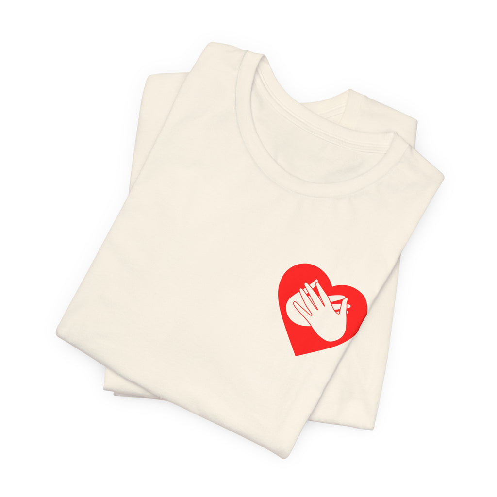 Folded natural T-Shirt showing a red coloured heart and the iconic BSL Love sign embedded in it on the left side of the chest
