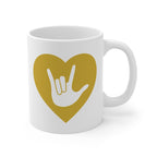 White mug with a gold coloured heart design featuring the ASL sign for I Love You embedded in it. The mug handle is on the right hand side of the mug.