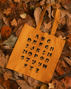 Orange Tote Bag with BSL Alphabet - Black Fingerspelling & Text on a background of autumn leaves