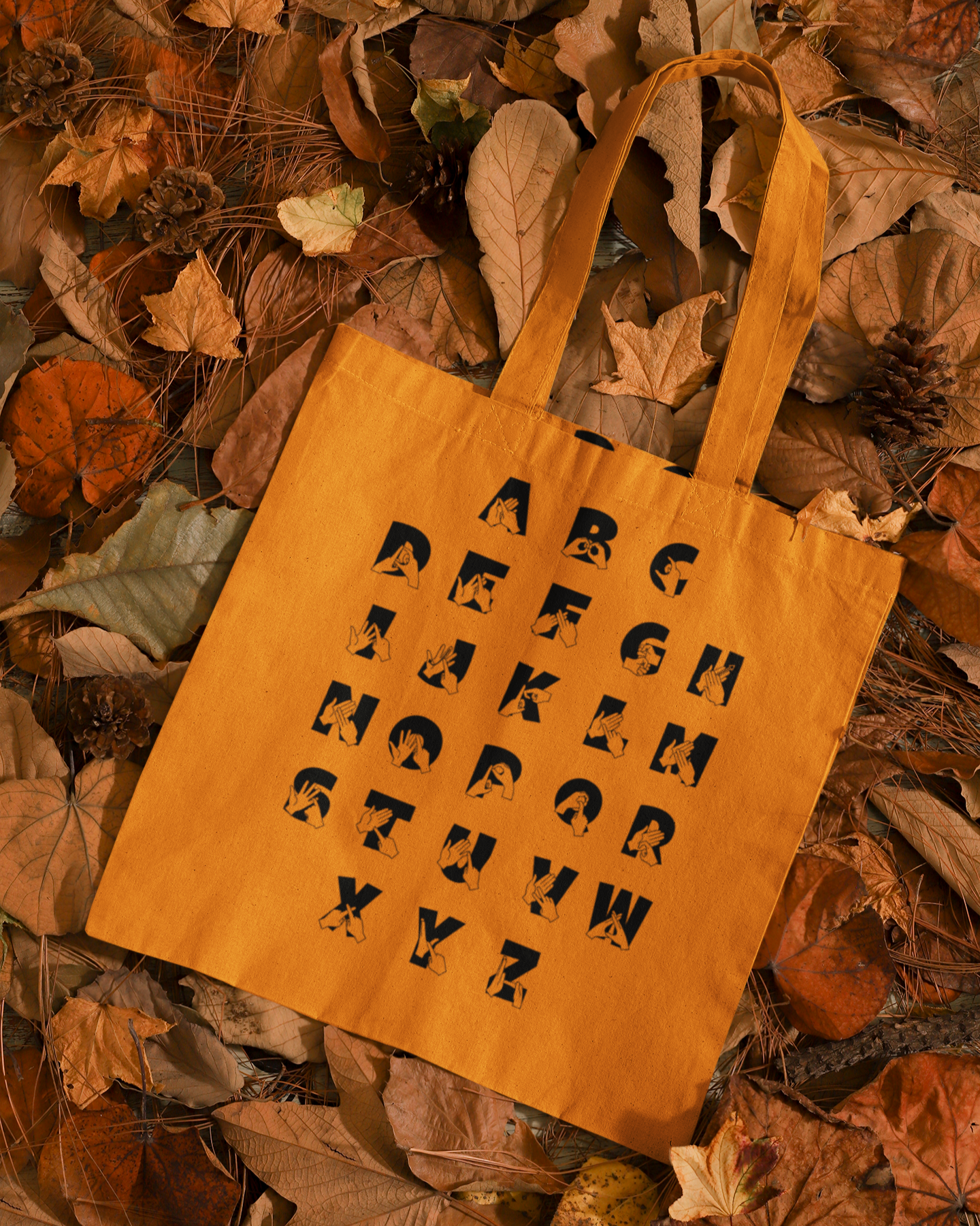Orange Tote Bag with BSL Alphabet - Black Fingerspelling & Text on a background of autumn leaves
