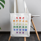 White Tote Bag with BSL Alphabet - Pride Fingerspelling & Text on a chair against a plain background
