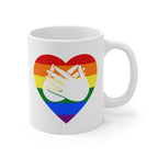 White mug with a pride coloured heart design featuring the BSL sign for Love embedded in it. The mug handle is on the right hand side of the mug.