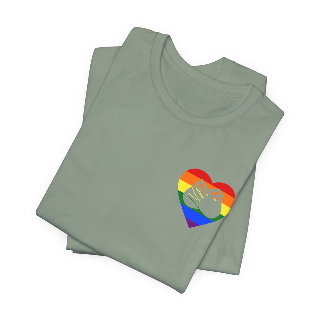 Folded sage T-Shirt showing a pride coloured heart and the iconic BSL Love sign embedded in it on the left side of the chest