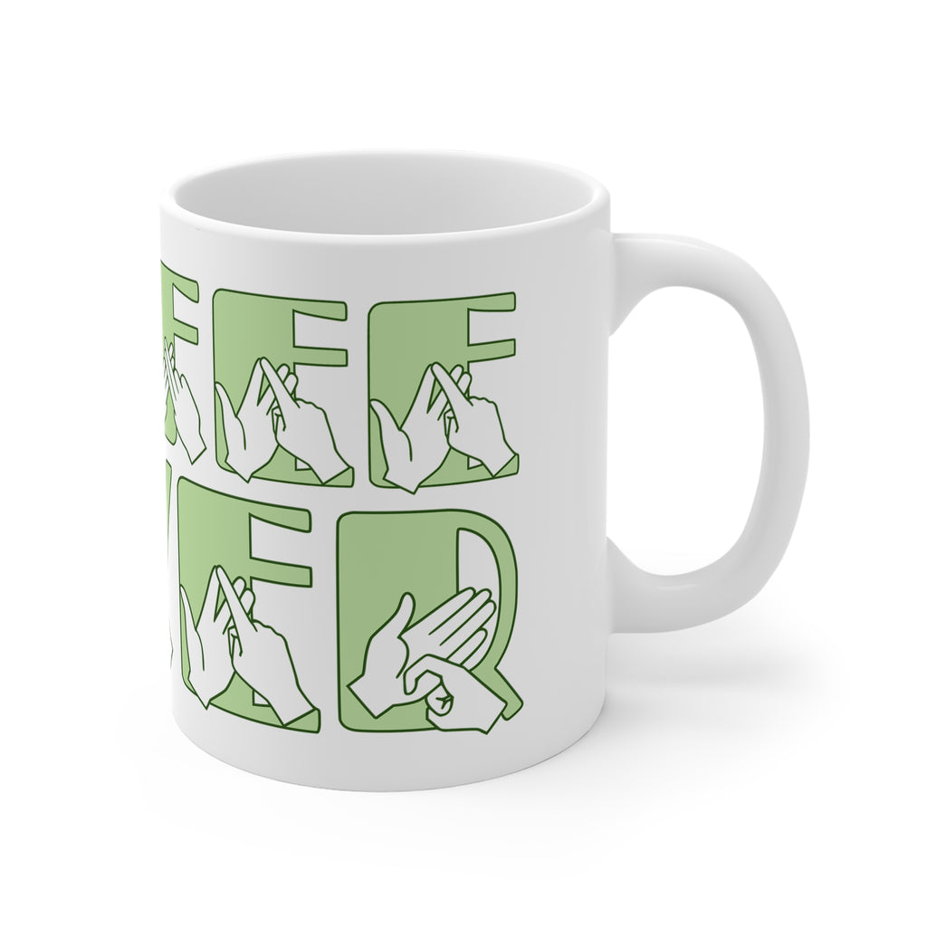 White mug featuring the phrase Coffee Lover written in BSL Fingerspelling and Text wrapping around the mug in green. The mug handle is on the right hand side of the mug.