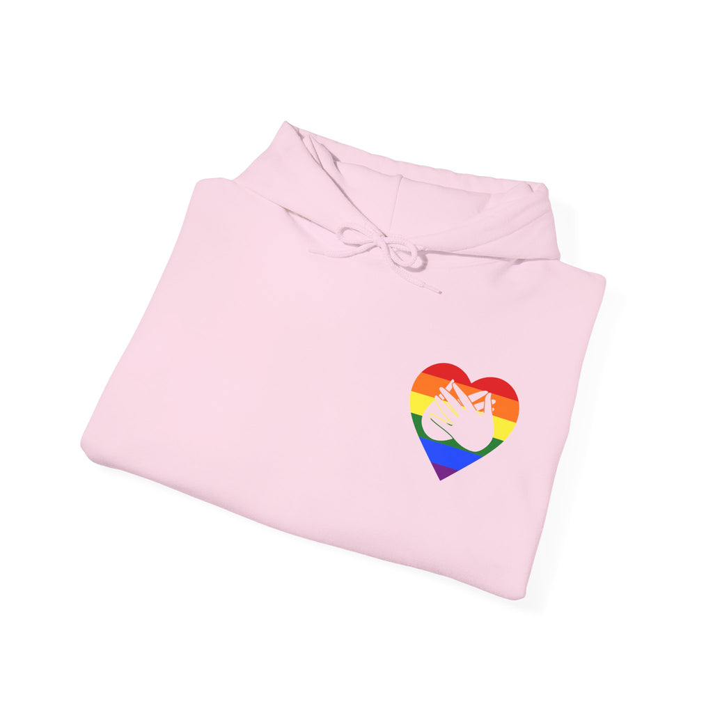 Folded light pink hoodie showing a pride coloured heart and the iconic BSL Love sign embedded in it on the left side of the chest