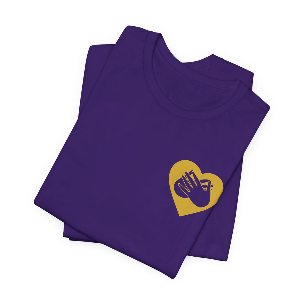 Folded team purple T-Shirt showing a gold coloured heart and the iconic BSL Love sign embedded in it on the left side of the chest