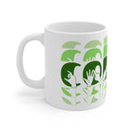 White mug featuring the phrase Coffee written in BSL Fingerspelling and Text wrapping around the mug in green cutaway design. The mug handle is on the left hand side of the mug.