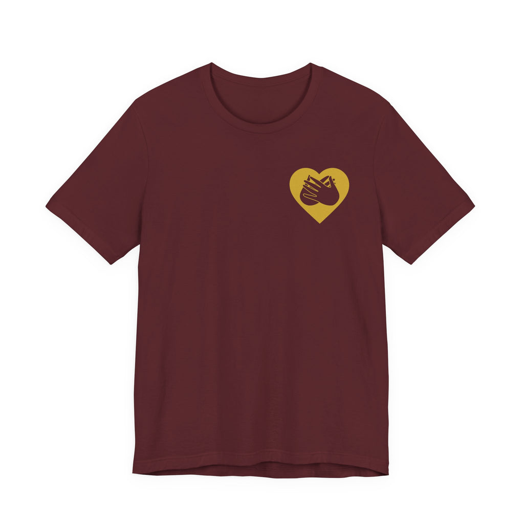 Front view of a maroon T-Shirt showing a gold coloured heart and the iconic BSL Love sign embedded in it on the left side of the chest