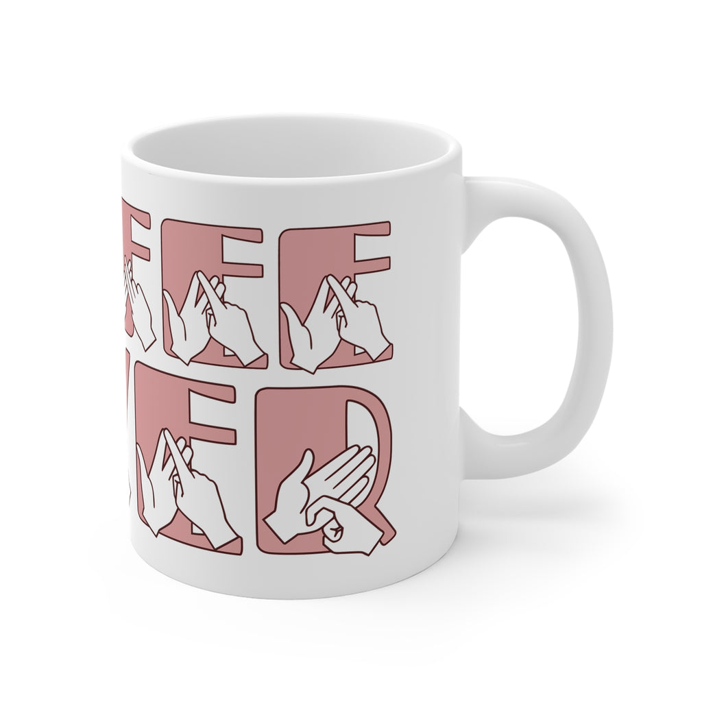 White mug featuring the phrase Coffee Lover written in BSL Fingerspelling and Text wrapping around the mug in pink. The mug handle is on the right hand side of the mug.