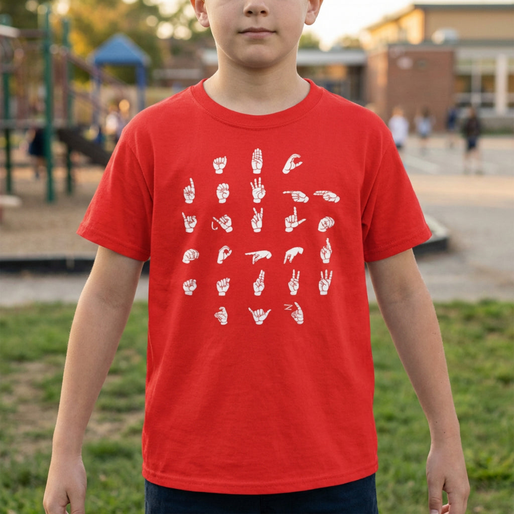 Child wearing a red t-shirt with white graphics in an outdoor setting