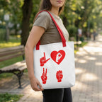 Person holding a white tote bag with red designs in a park