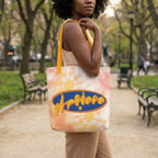 Person holding a tote bag with a colorful design in a park