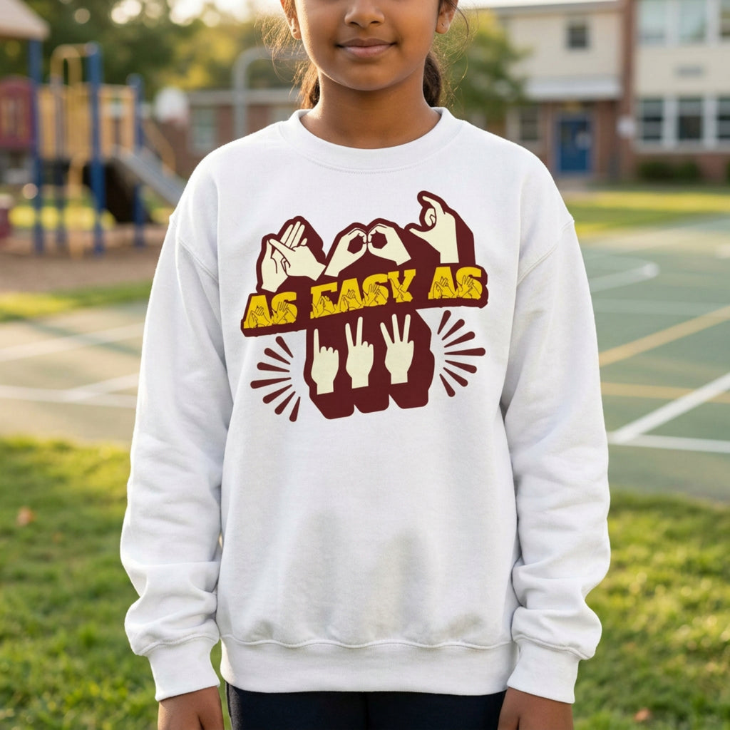 Child wearing a white sweatshirt with a graphic design on a school playground.