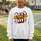 Child wearing a white sweatshirt with a graphic design on a school playground.