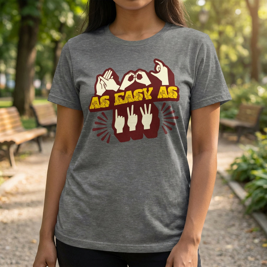 Person wearing a gray t-shirt with a graphic design and text in an outdoor setting