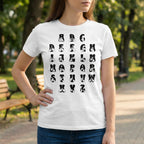 Person wearing a white t-shirt with black letter designs outdoors.