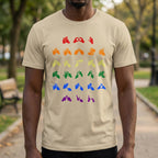 Person wearing a beige t-shirt with pride rainbow coloured fingerspelling designs outdoors.