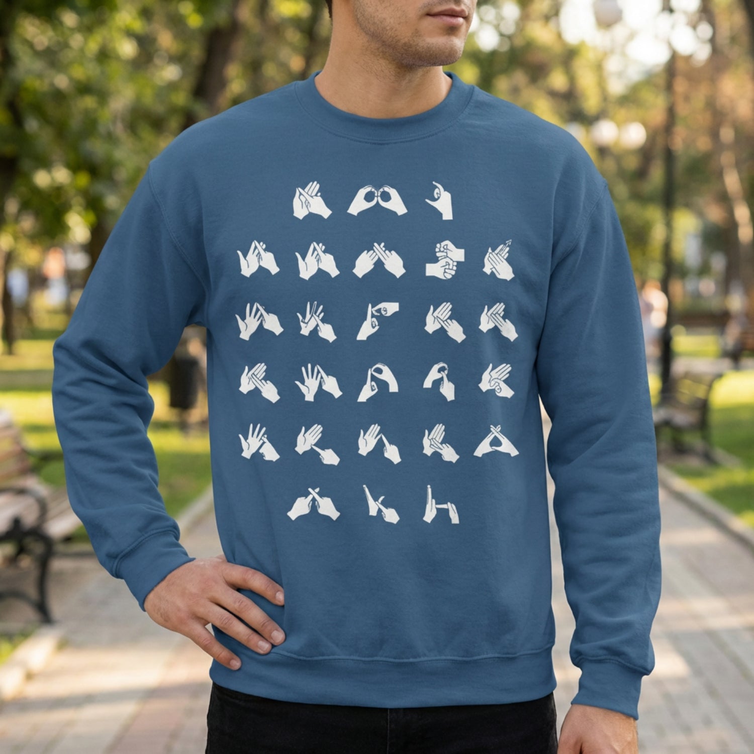 Person wearing a blue sweatshirt with white fingerspelling in a park setting