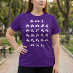 Person wearing a purple t-shirt with white fingerspelling design in an outdoor setting