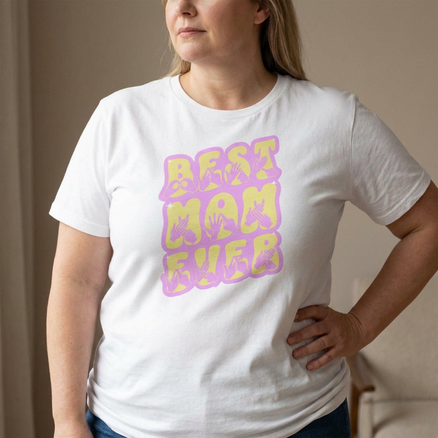 Person wearing a white t-shirt with 'BEST MOM EVER' in purple and yellow.