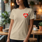Person wearing a beige t-shirt with a red heart design in a cafe setting