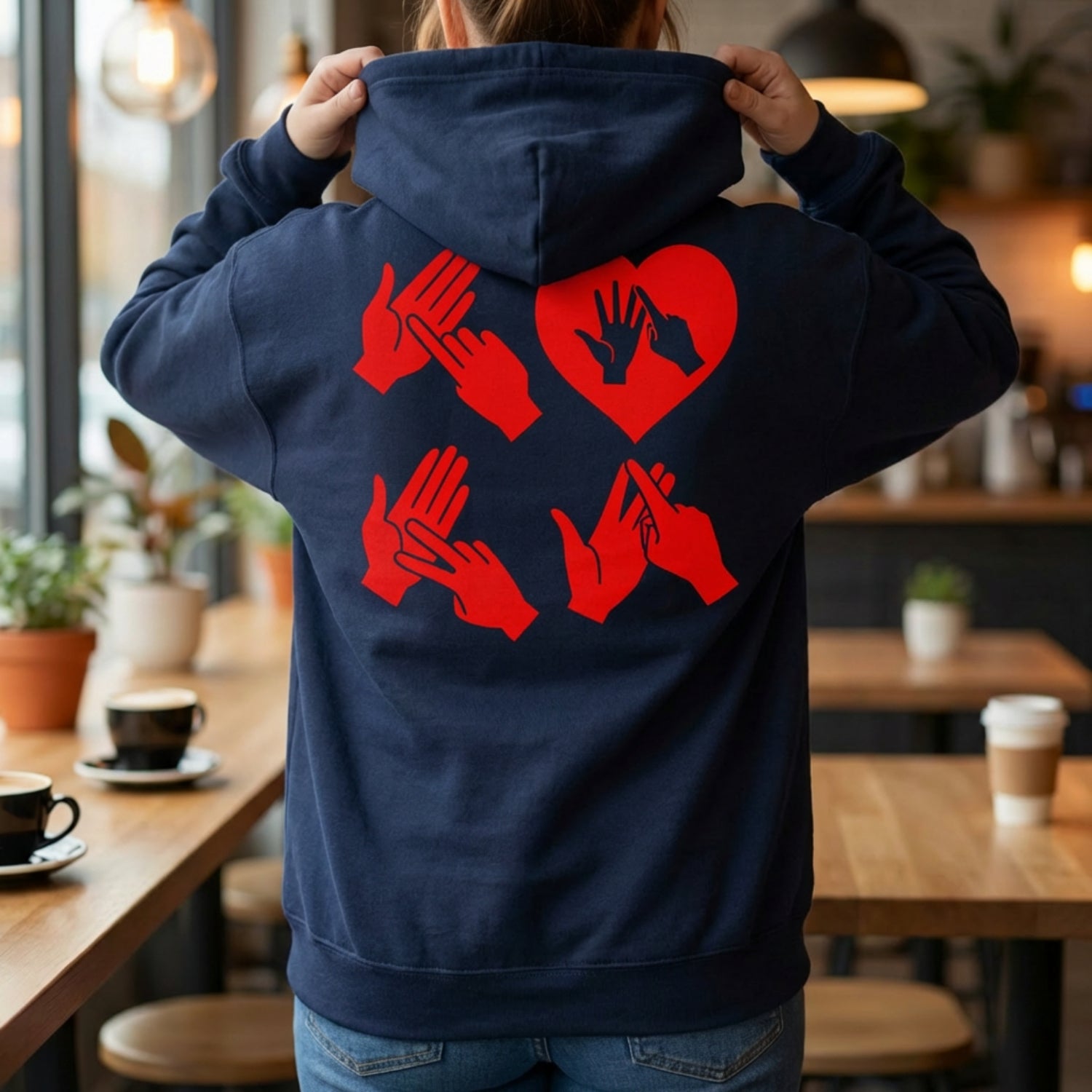 Back view of a person wearing a hoodie with red fingerspelling design.
