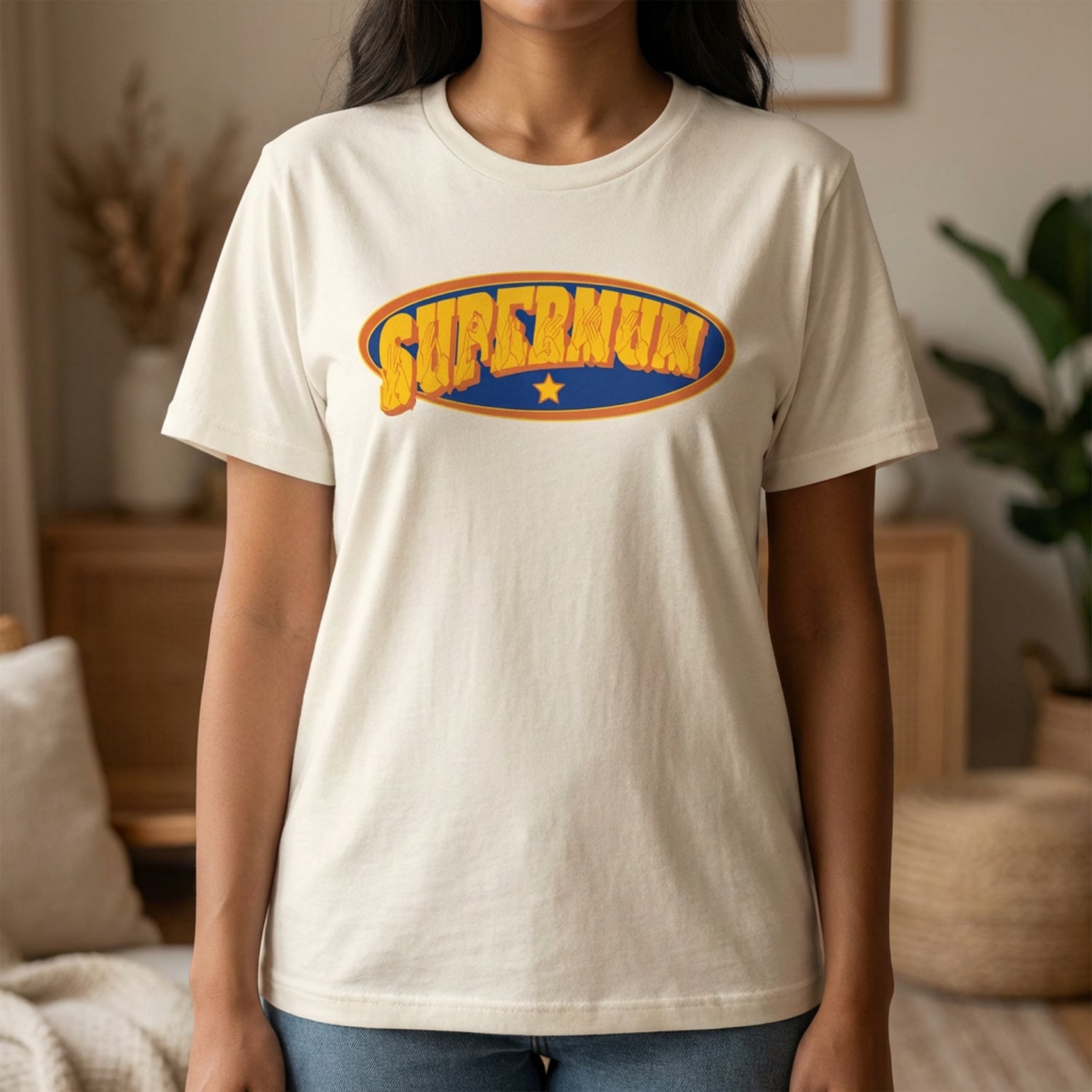 Person wearing a natural t-shirt with 'Supermum' graphic in a home setting