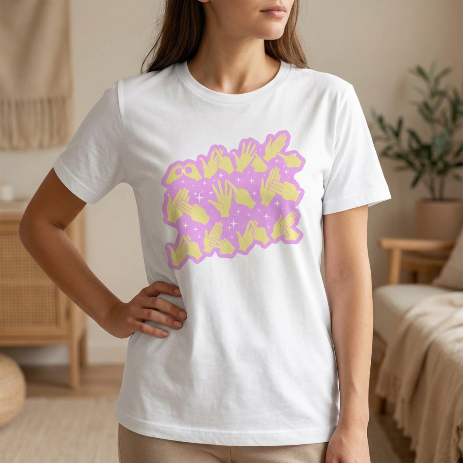Person wearing a white t-shirt with a purple and yellow graphic design in a casual setting.