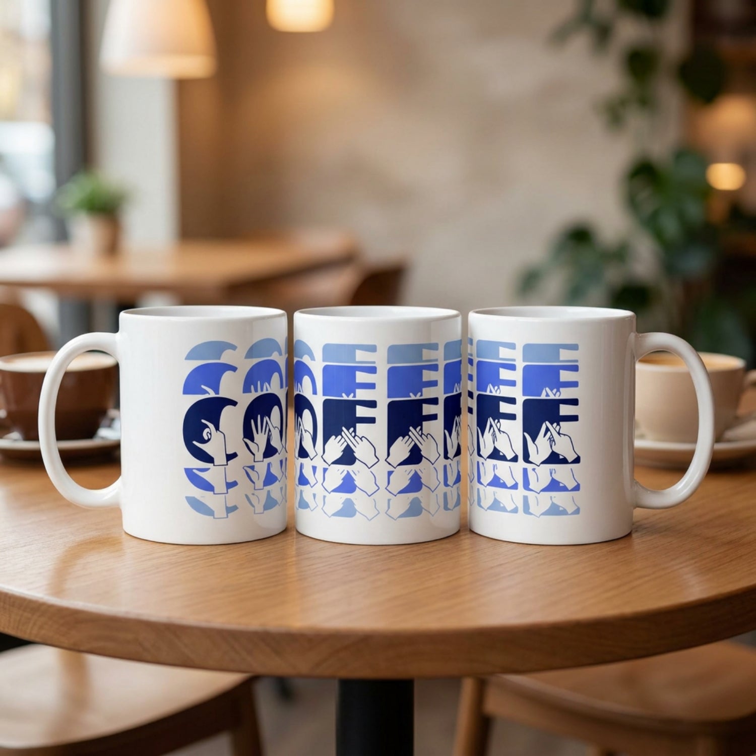Three mugs with 'Coffee'  cutaway design in blue on a wooden table in a cafe setting.