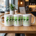 Three mugs with 'Coffee'  cutaway design in green on a wooden table in a cafe setting.