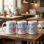 Three mugs with 'Coffee Lover' design in blue on a wooden table in a cafe setting.