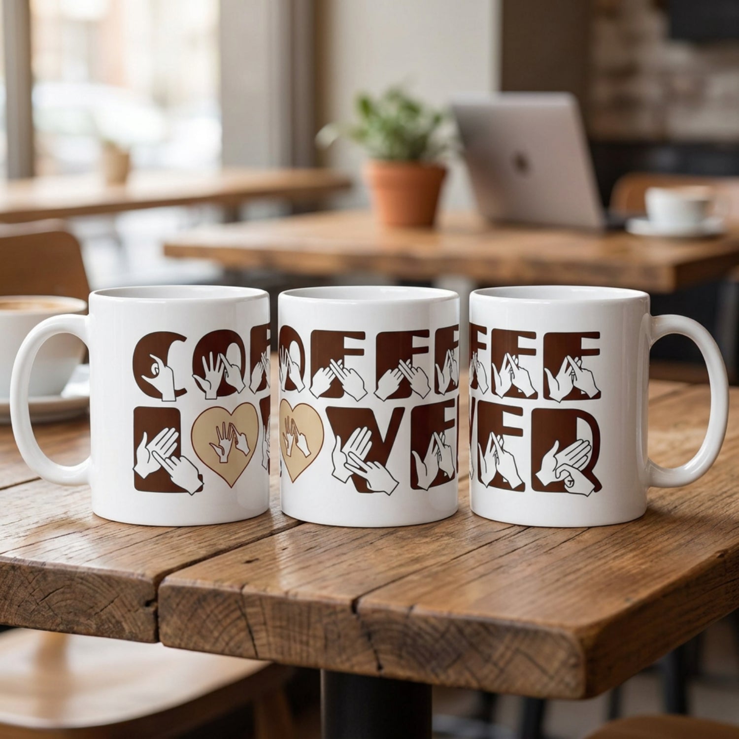 Three mugs with 'Coffee Lover' design in brown on a wooden table in a cafe setting.