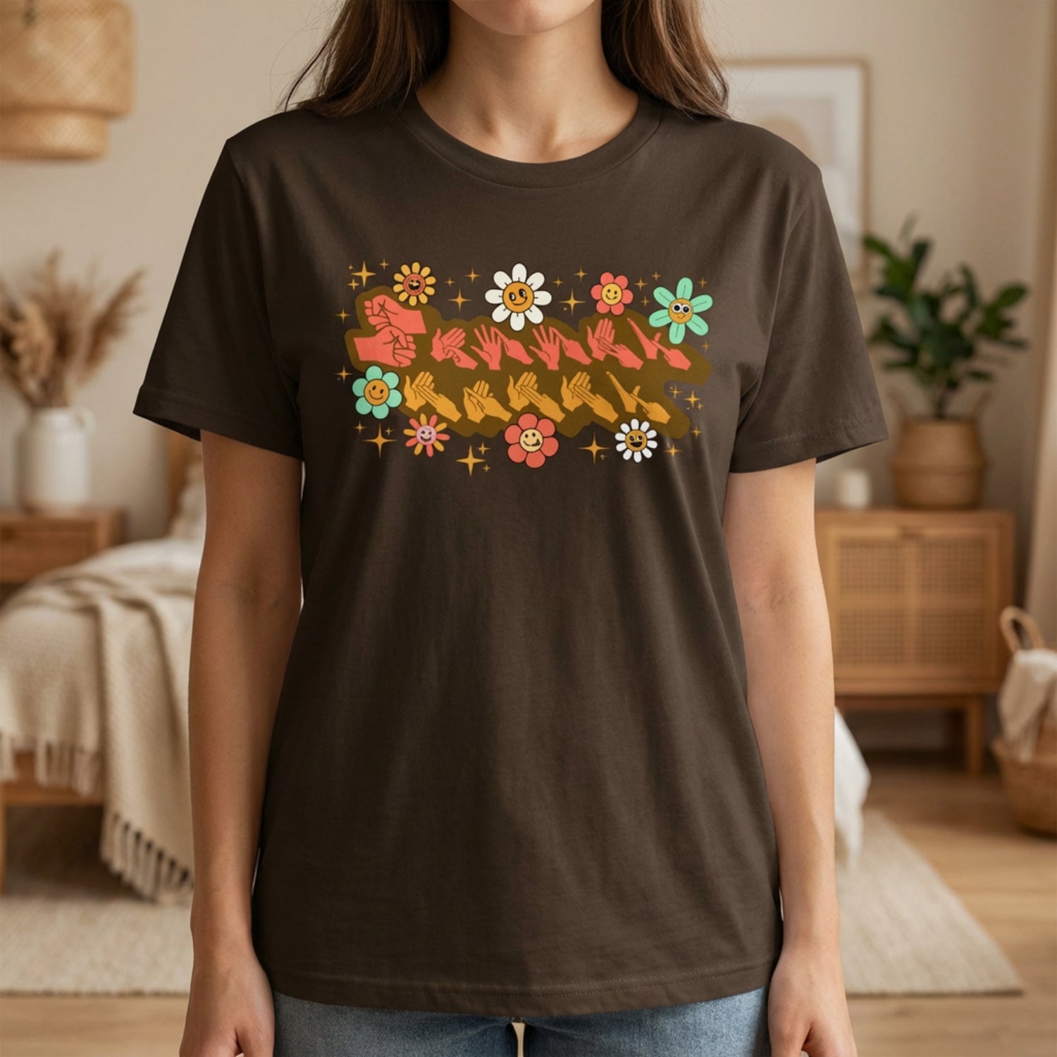 Person wearing a brown t-shirt with colorful graphic design in a room.