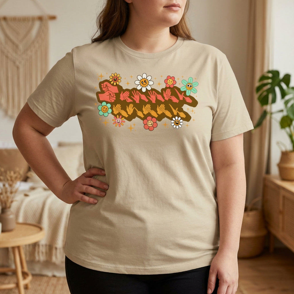 Person wearing a beige t-shirt with a colorful graphic design in a home setting