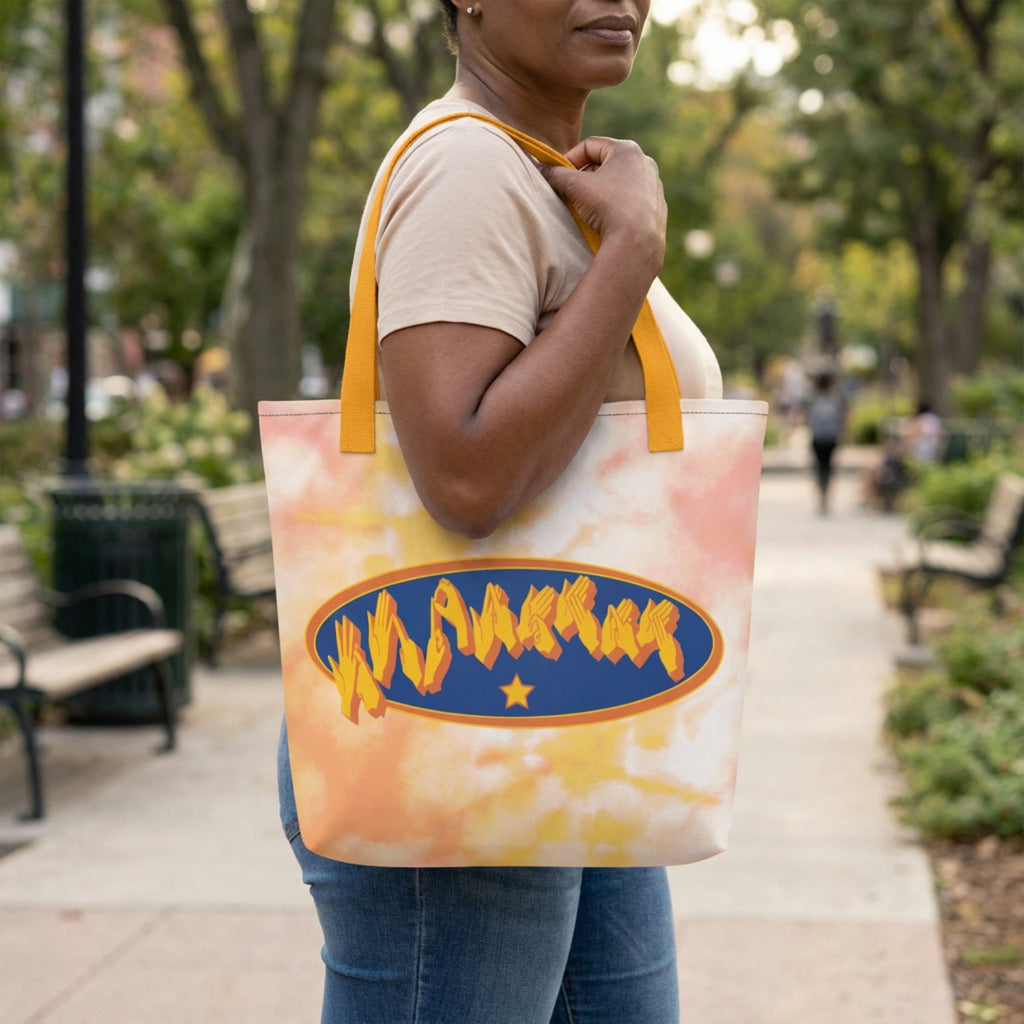 Person holding a tote bag with a colorful design in a park setting