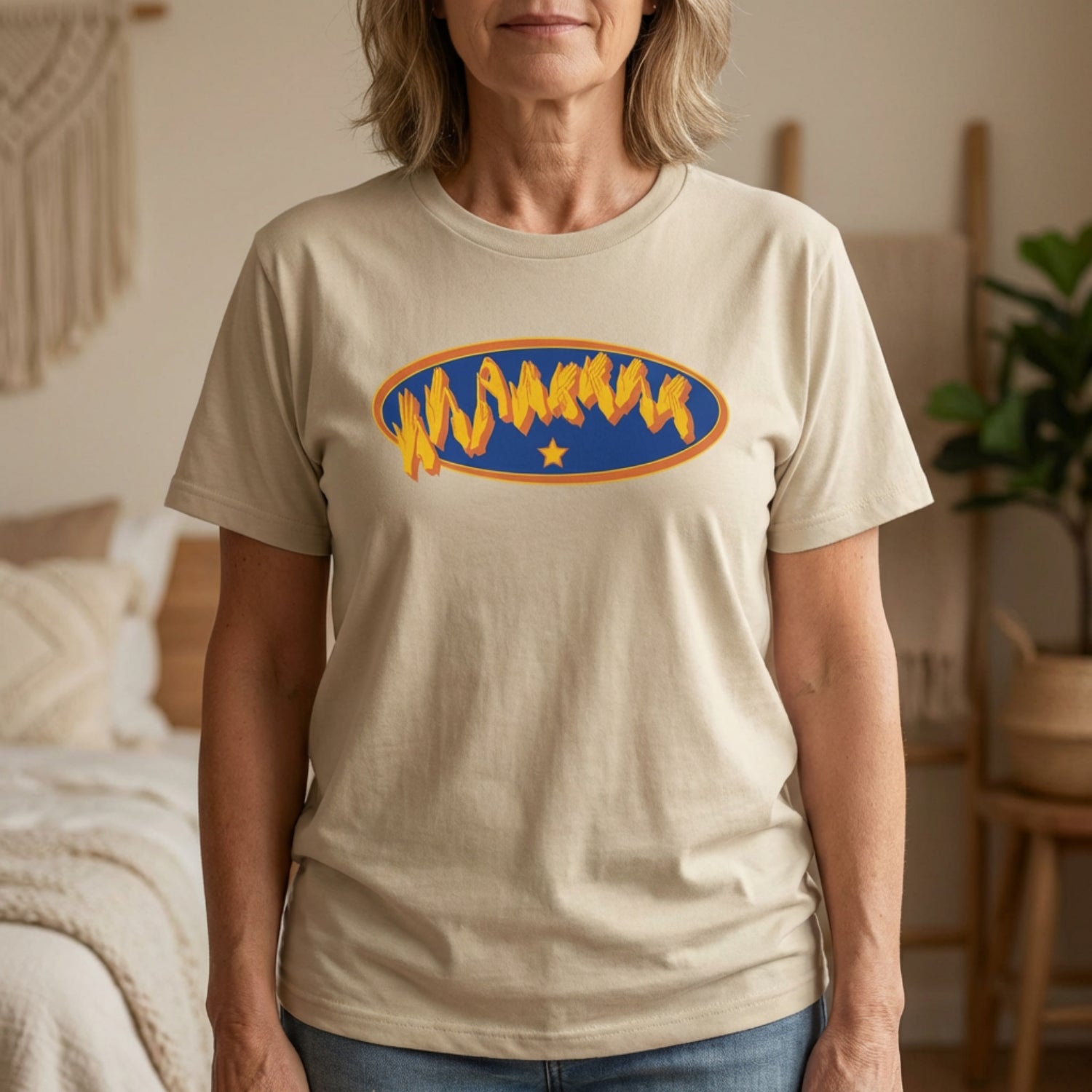 Person wearing a sand t-shirt with a graphic design in a home setting