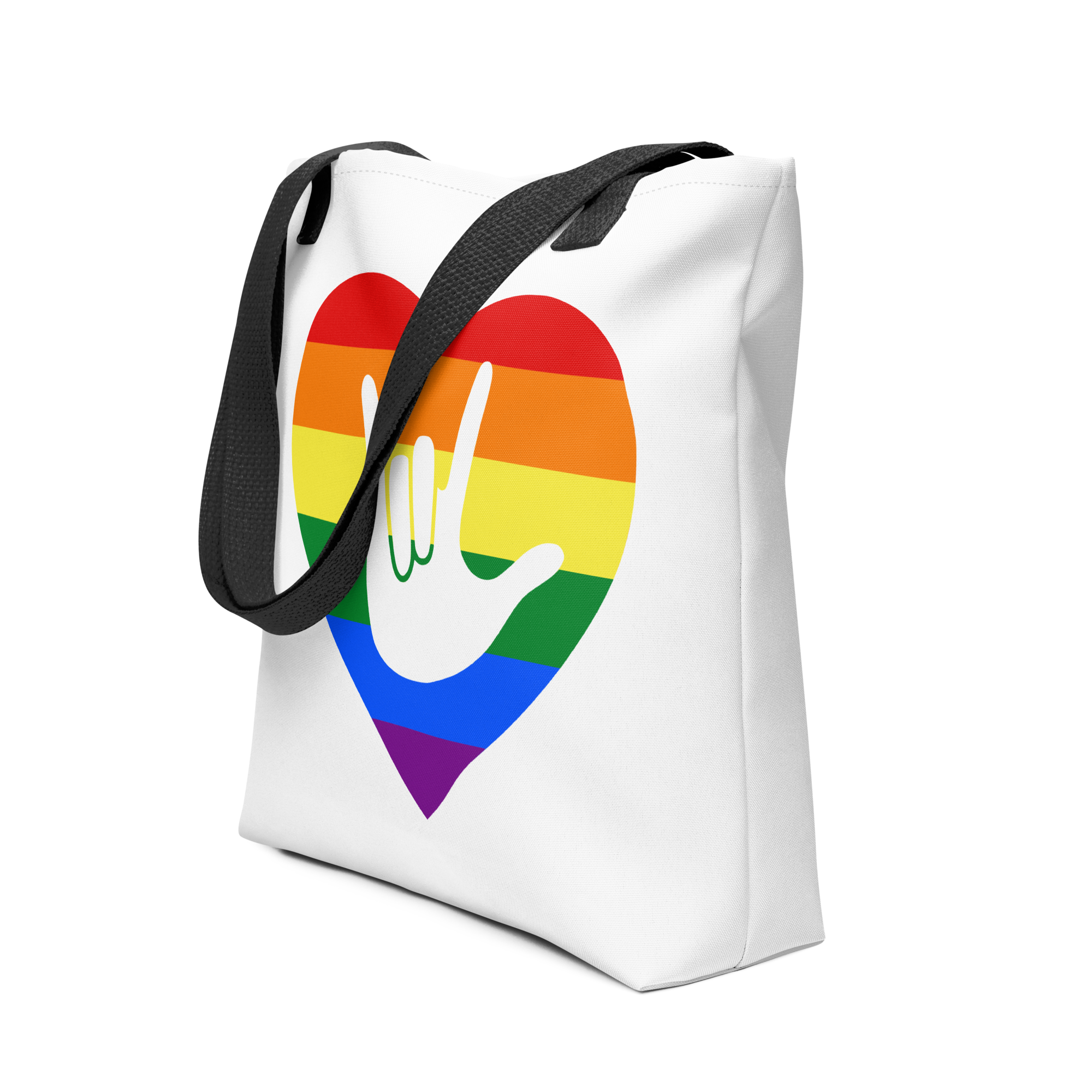 An angled view of a white Tote bag with a black handle and a pride heart with the ASL I love you sign at its center.