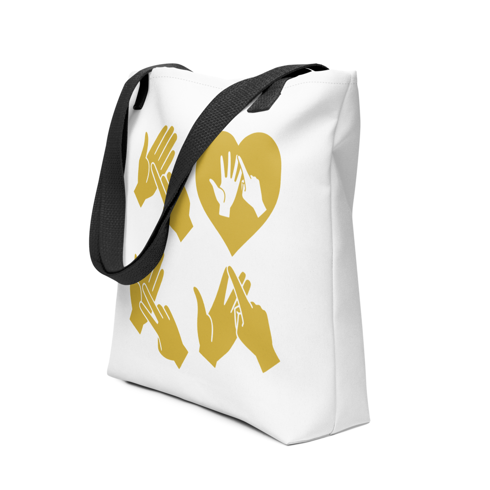 An angled view of a white Tote Bag with black handle showing the word Love in gold BSL Fingerspelling with the 'O' embedded in a heart shape