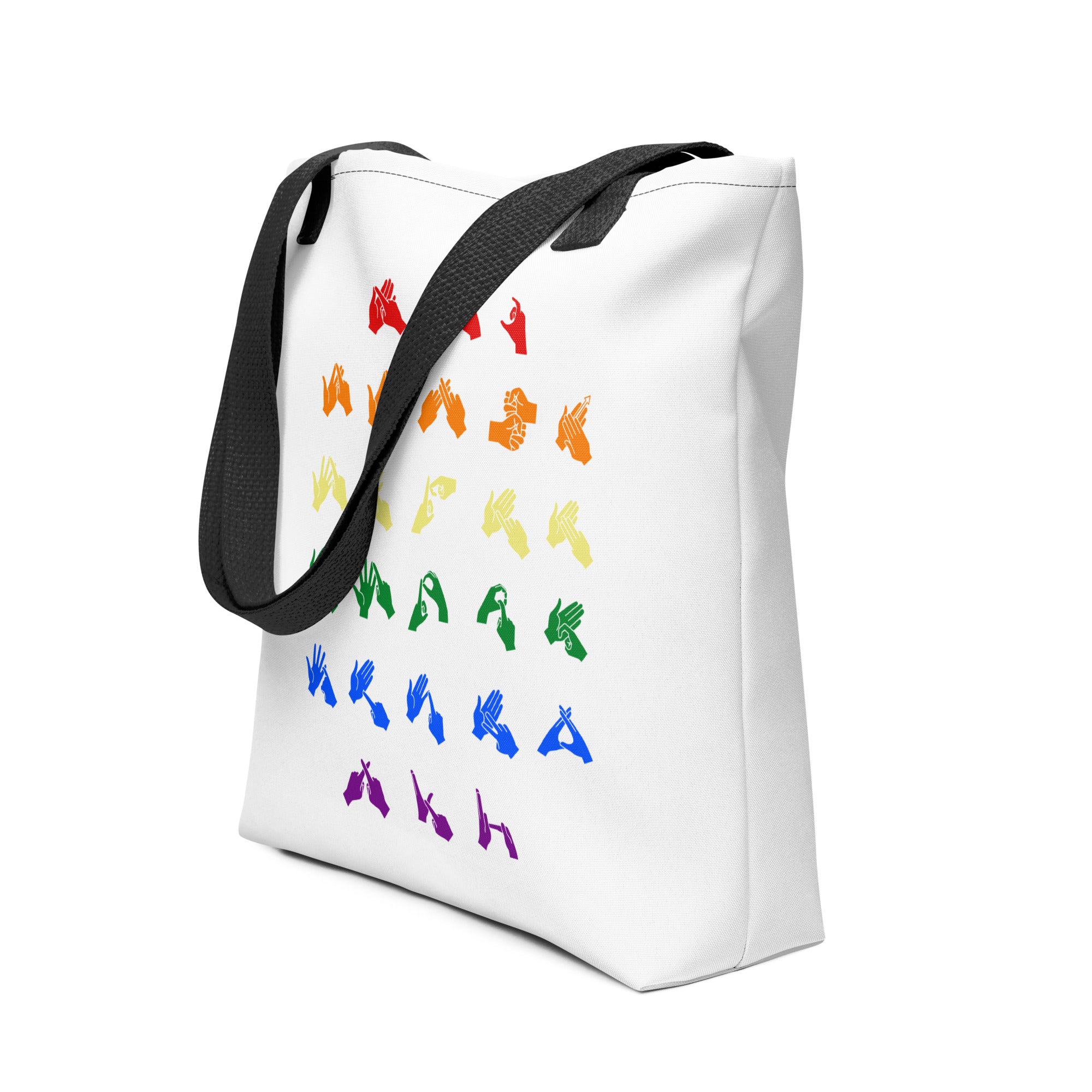 An angled view of a white Tote Bag with black handles showing the BSL Alphabet - Pride Fingerspelling