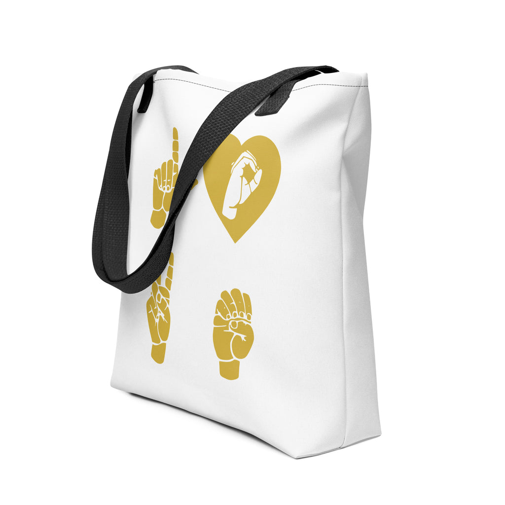 An angled view of a white Tote Bag with black handle showing the word Love in gold ASL Fingerspelling with the 'O' embedded in a heart shape